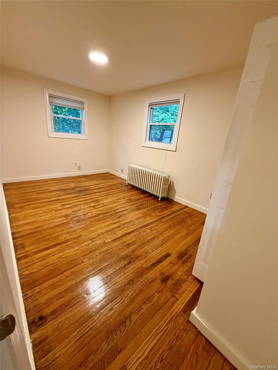 Bedroom 3 with light wood finished floors and radiator heating unit Bedroom 3 with light wood finished floors and radiator heating unit