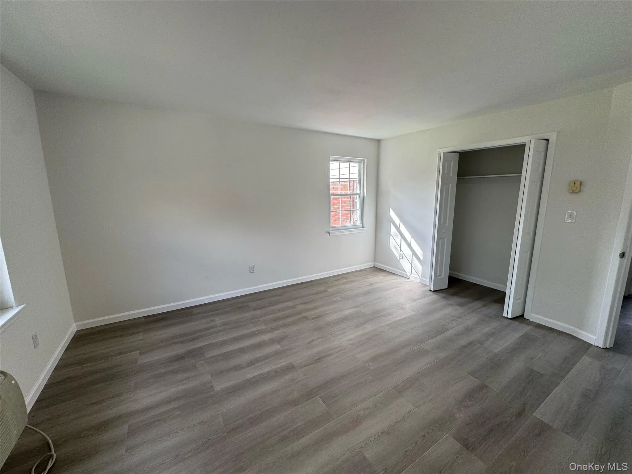 Unfurnished bedroom with wood finished floors and a closet Unfurnished bedroom with wood finished floors and a closet