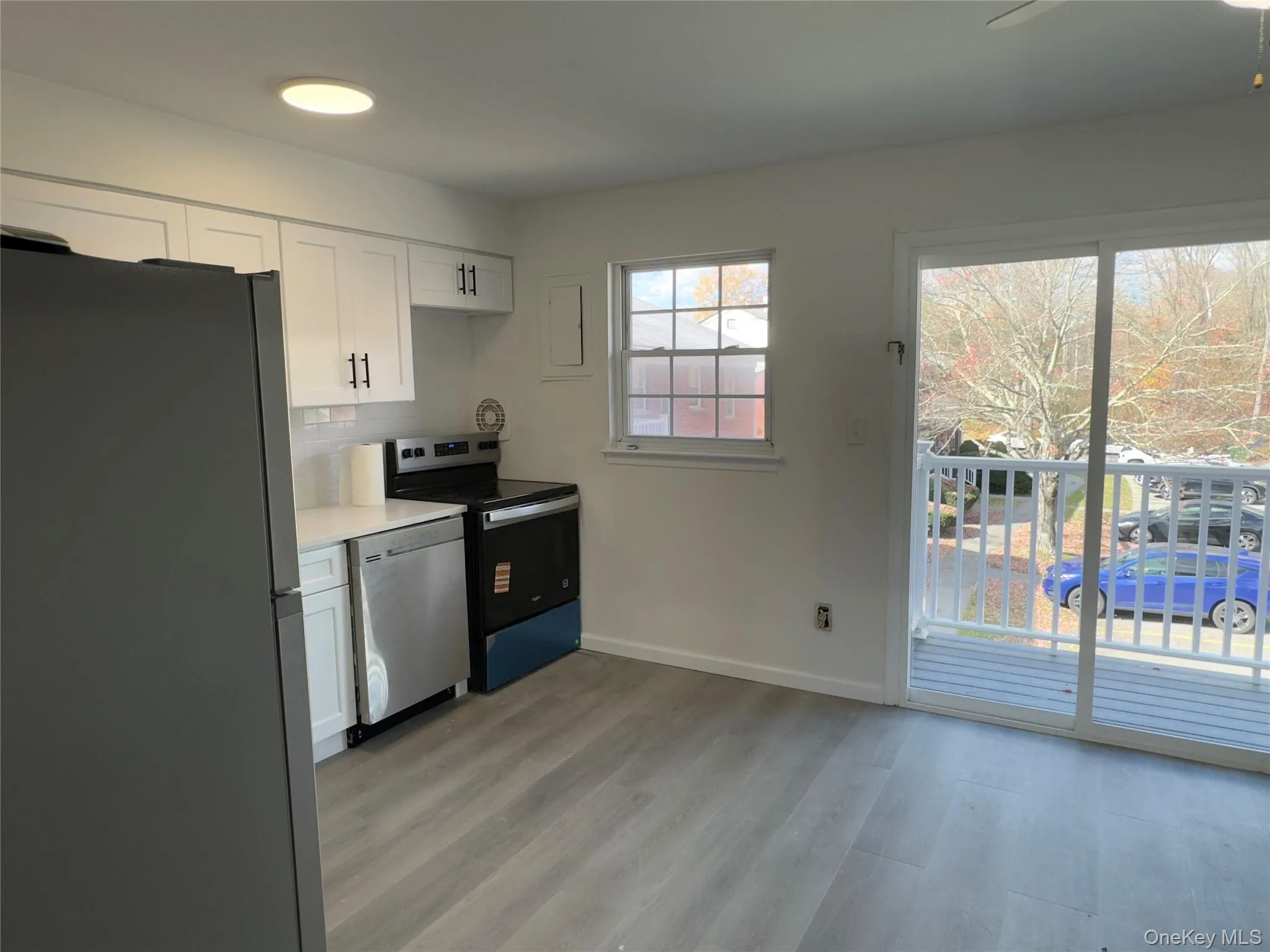 Kitchen featuring appliances with stainless steel finishes, white cabinetry, light countertops, and light wood-style flooring Kitchen featuring appliances with stainless steel finishes, white cabinetry, light countertops, and light wood-style flooring