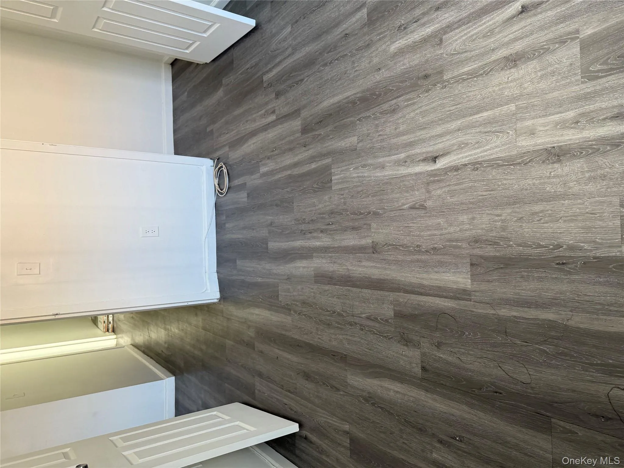 Unfurnished bedroom with dark wood finished floors and baseboards Unfurnished bedroom with dark wood finished floors and baseboards