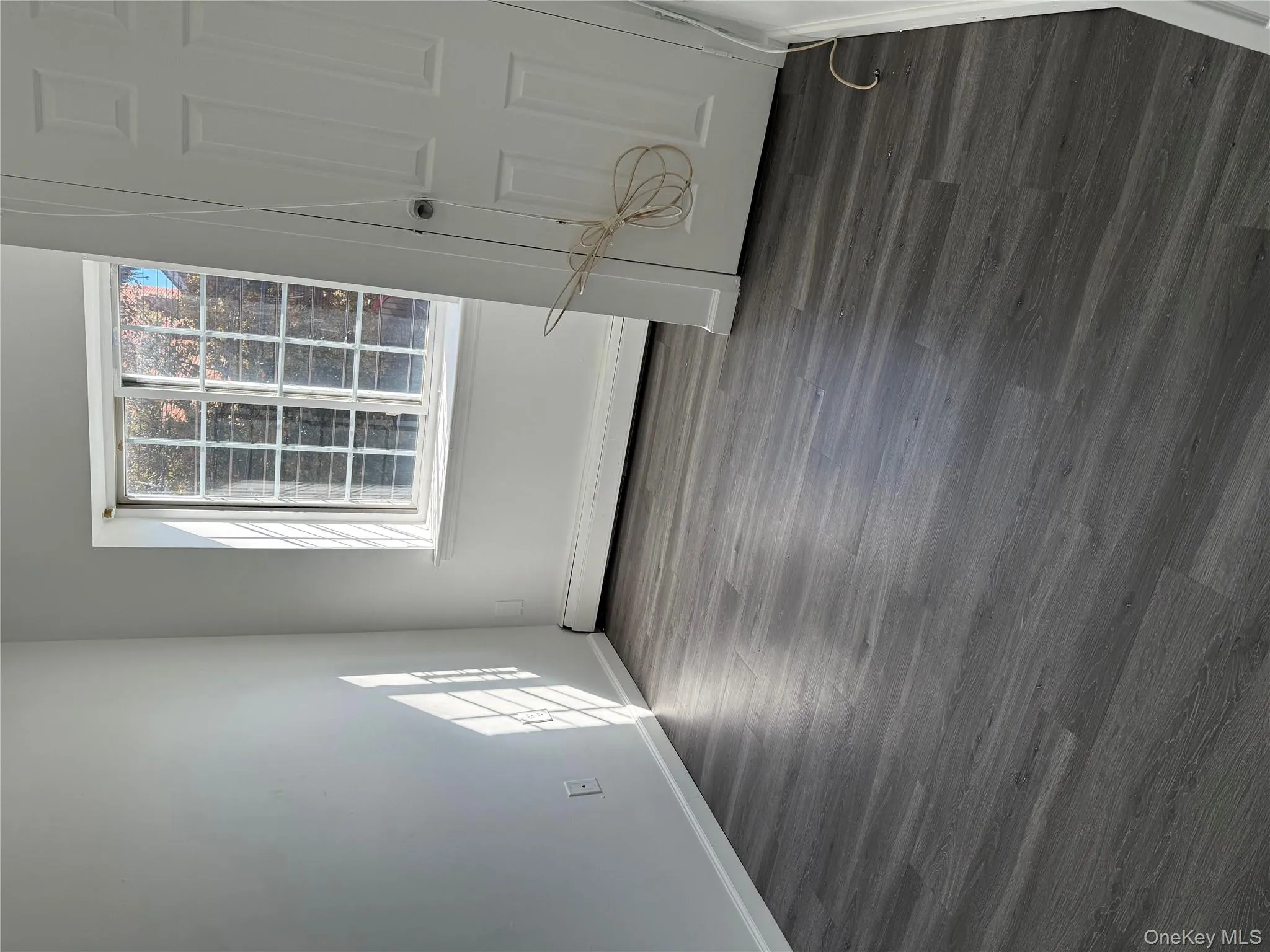 Unfurnished bedroom featuring dark wood finished floors and a baseboard heating unit Unfurnished bedroom featuring dark wood finished floors and a baseboard heating unit