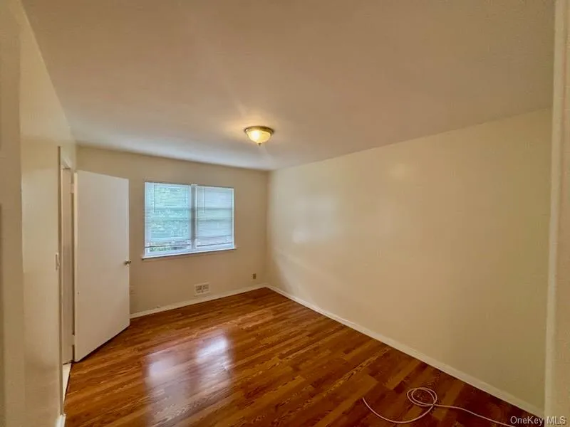 Unfurnished bedroom with wood finished floors and baseboards Unfurnished bedroom with wood finished floors and baseboards
