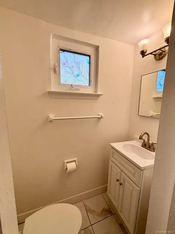 Half bathroom featuring vanity and light tile patterned floors Half bathroom featuring vanity and light tile patterned floors
