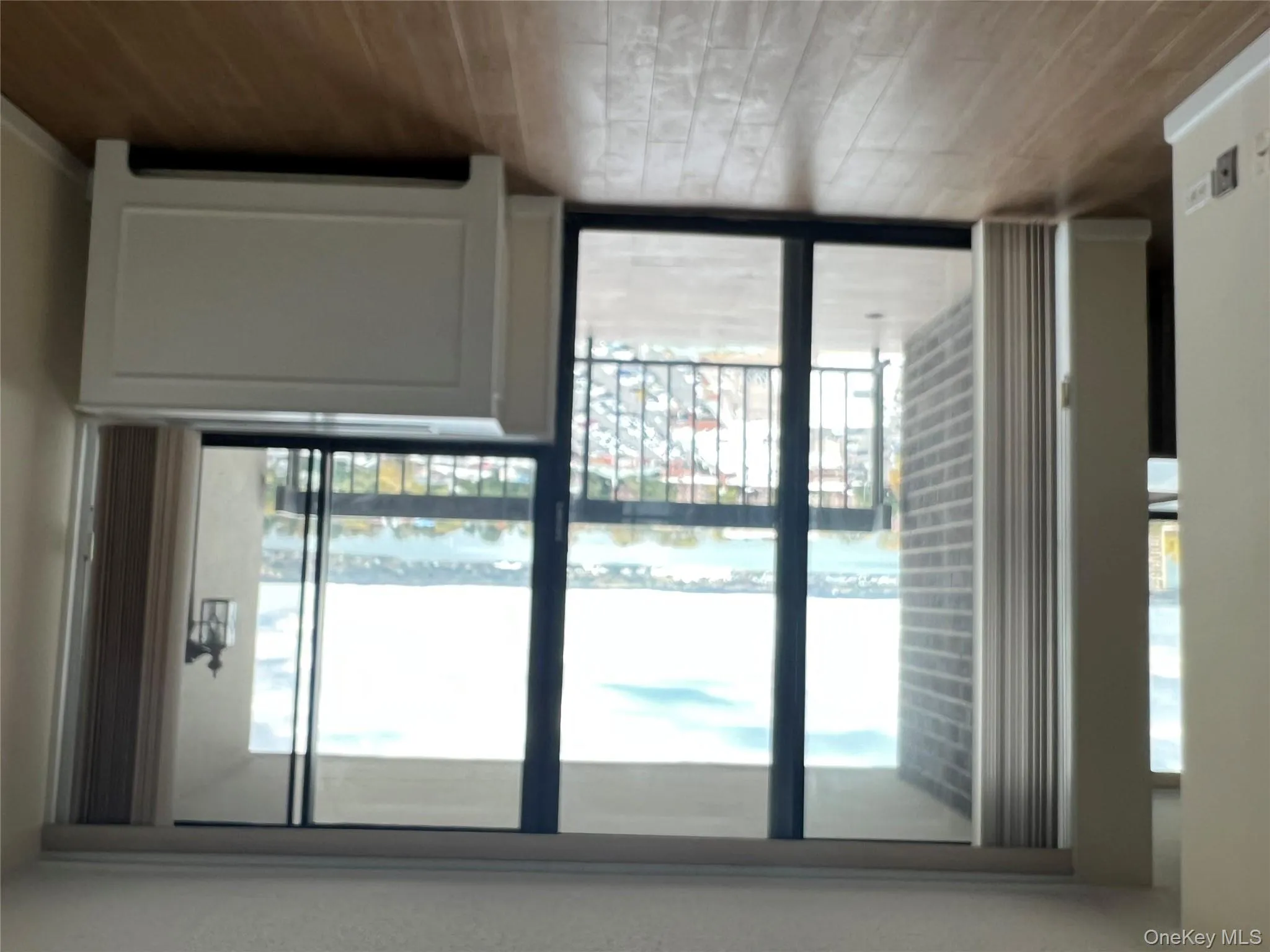 Entryway featuring wood finished floors, a water view, expansive windows, and a textured ceiling Entryway featuring wood finished floors, a water view, expansive windows, and a textured ceiling