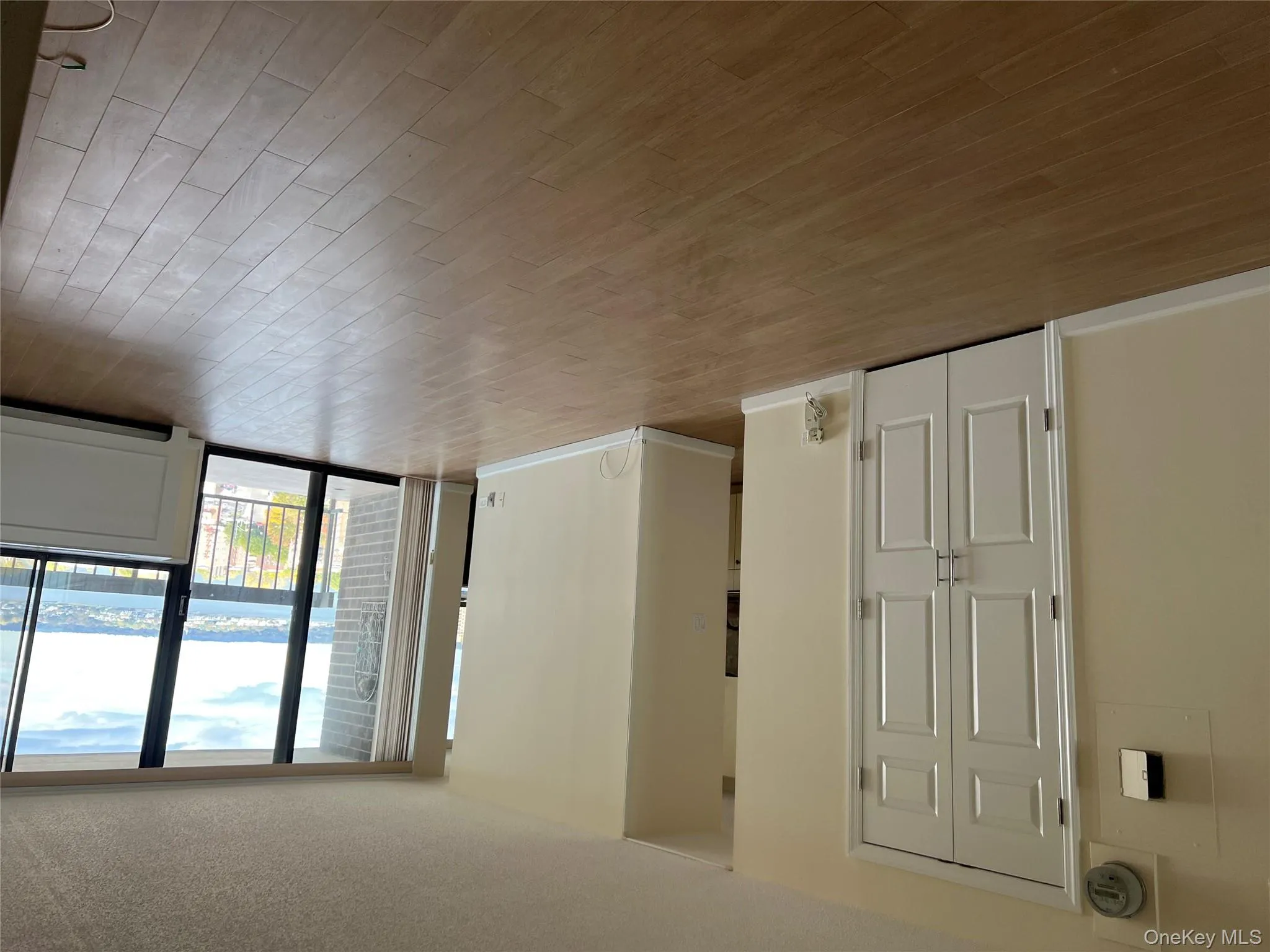 Unfurnished room featuring floor to ceiling windows, wood finished floors, a water view, and a textured ceiling Unfurnished room featuring floor to ceiling windows, wood finished floors, a water view, and a textured ceiling
