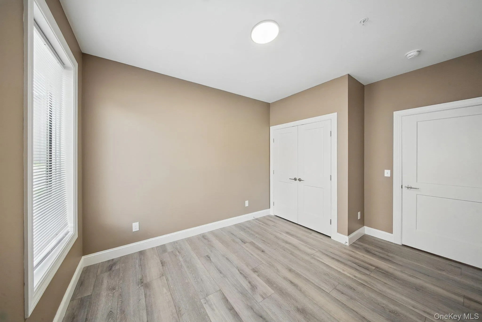 Unfurnished bedroom featuring light wood-style floors and a closet Unfurnished bedroom featuring light wood-style floors and a closet