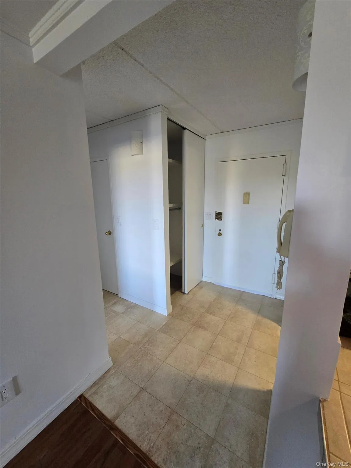 Hallway featuring baseboards and a textured ceiling Hallway featuring baseboards and a textured ceiling