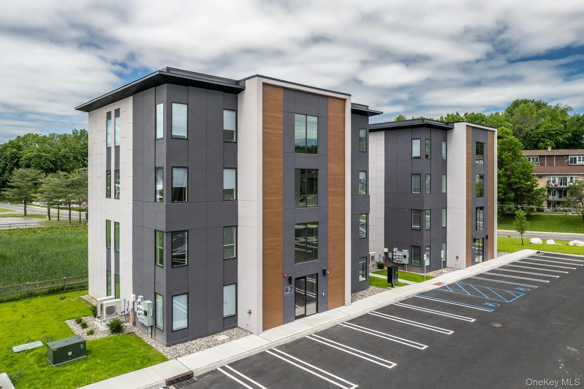 View of building exterior featuring uncovered parking View of building exterior featuring uncovered parking