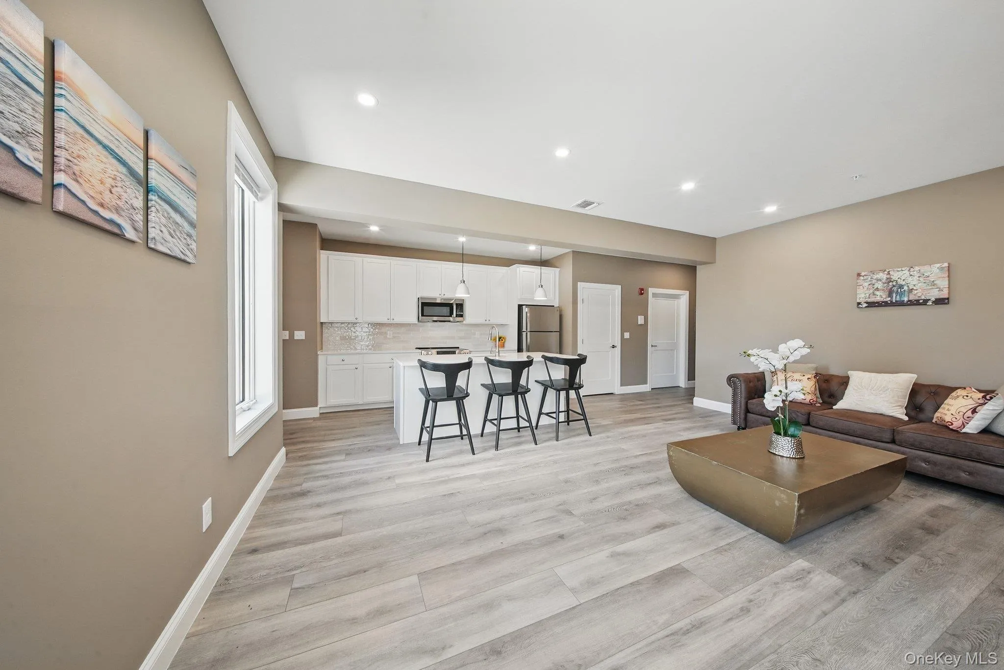 Living area with light wood-style flooring and recessed lighting Living area with light wood-style flooring and recessed lighting
