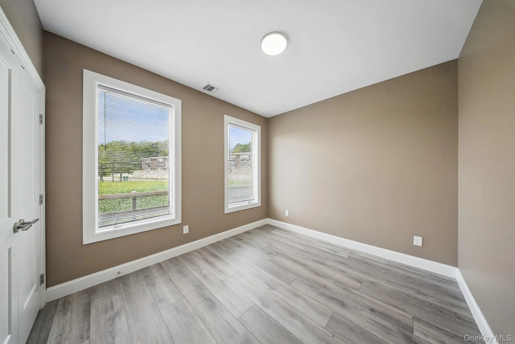 Spare room featuring baseboards and light wood-style floors Spare room featuring baseboards and light wood-style floors