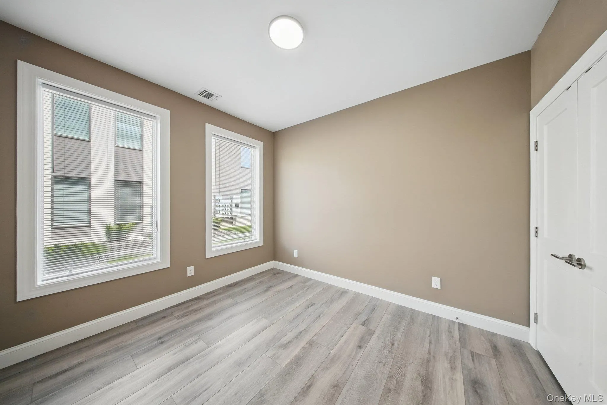 Empty room featuring light wood-style flooring and baseboards Empty room featuring light wood-style flooring and baseboards