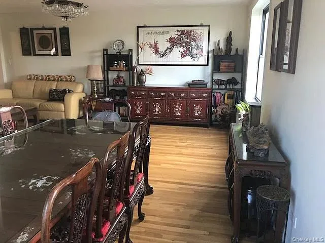 Dining space with light wood-style flooring and a chandelier Dining space with light wood-style flooring and a chandelier