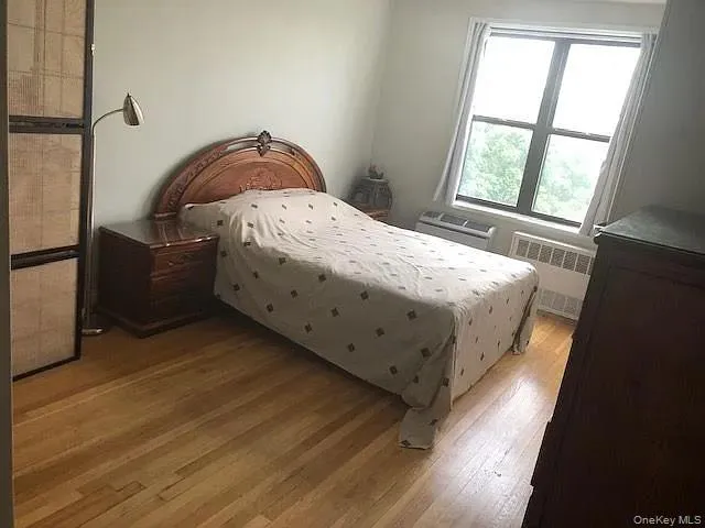 Bedroom featuring wood finished floors and radiator Bedroom featuring wood finished floors and radiator