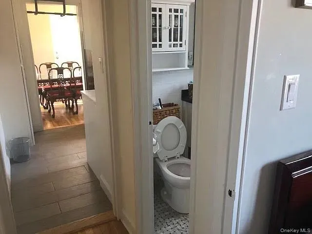 Bathroom featuring toilet and dark wood-style floors Bathroom featuring toilet and dark wood-style floors