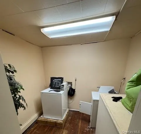 Washroom featuring washer / clothes dryer and dark wood-style flooring Washroom featuring washer / clothes dryer and dark wood-style flooring