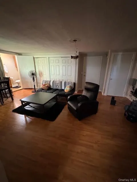 Living room featuring wood finished floors and a chandelier Living room featuring wood finished floors and a chandelier