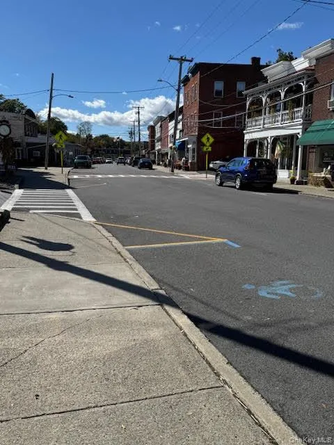 View of asphalt road with sidewalks, curbs, street lighting, and traffic signs View of asphalt road with sidewalks, curbs, street lighting, and traffic signs