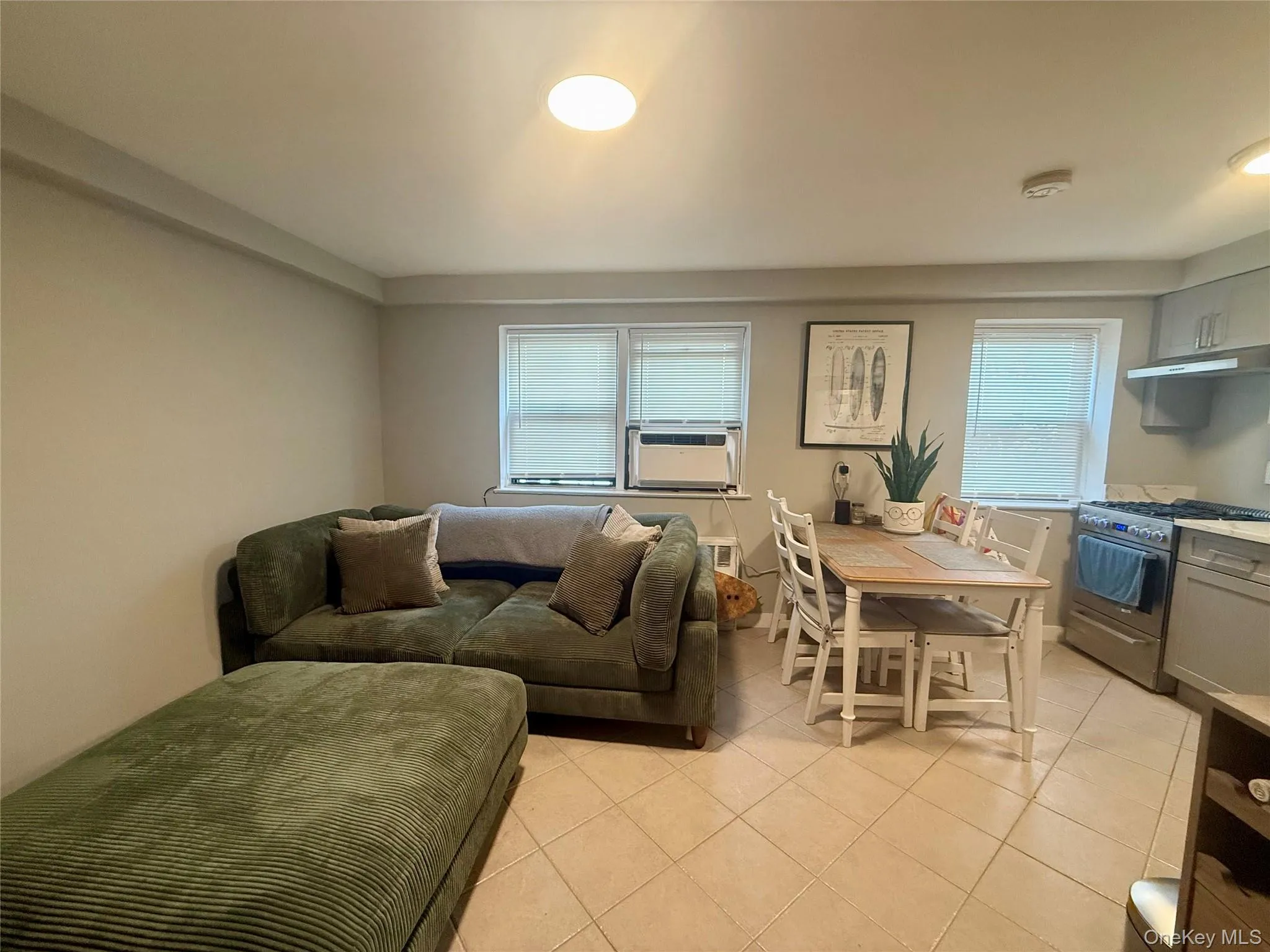Living area with light tile patterned floors and cooling unit Living area with light tile patterned floors and cooling unit