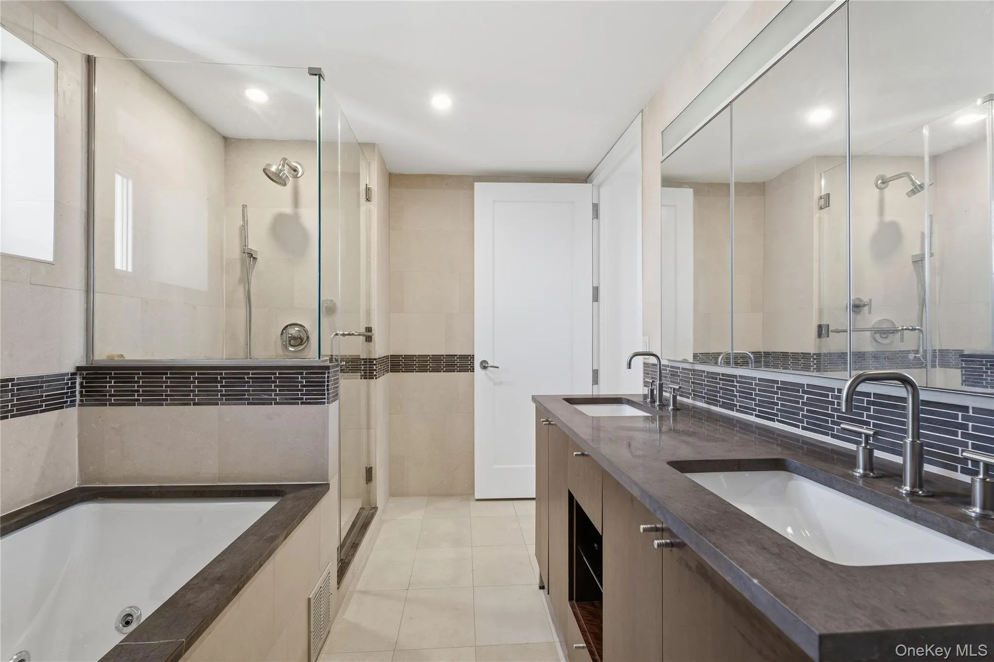 Bathroom featuring double vanity, light tile patterned floors, a whirlpool tub, a stall shower, and recessed lighting Bathroom featuring double vanity, light tile patterned floors, a whirlpool tub, a stall shower, and recessed lighting