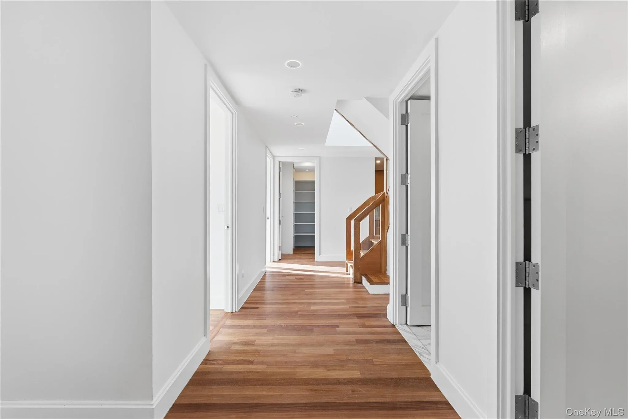 Hallway with light wood-style flooring and stairs Hallway with light wood-style flooring and stairs