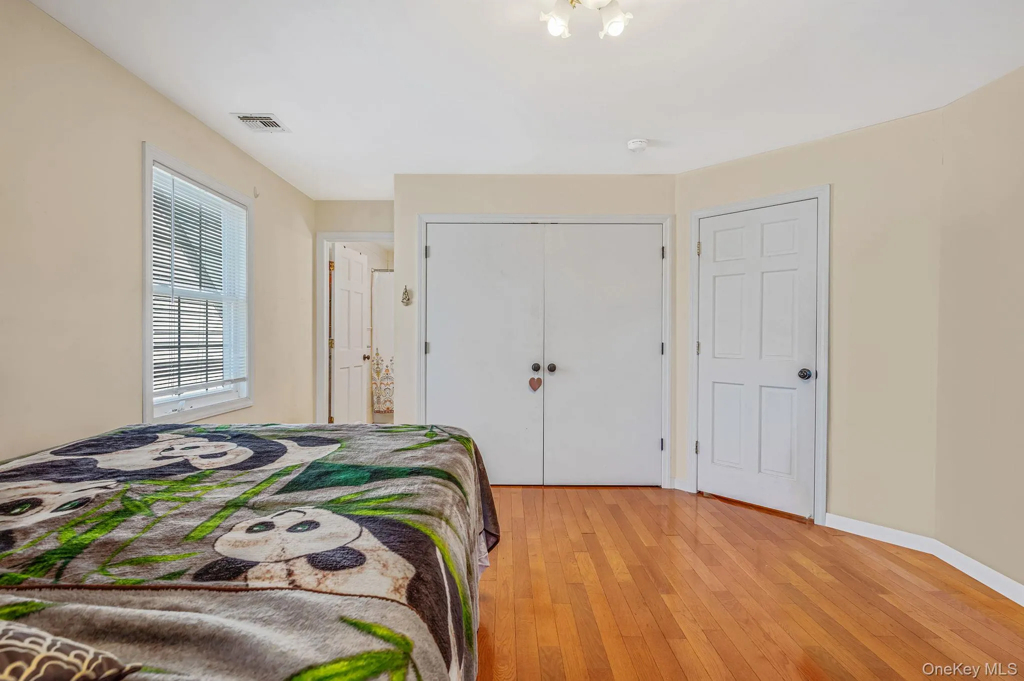 Bedroom featuring light wood finished floors and a closet Bedroom featuring light wood finished floors and a closet