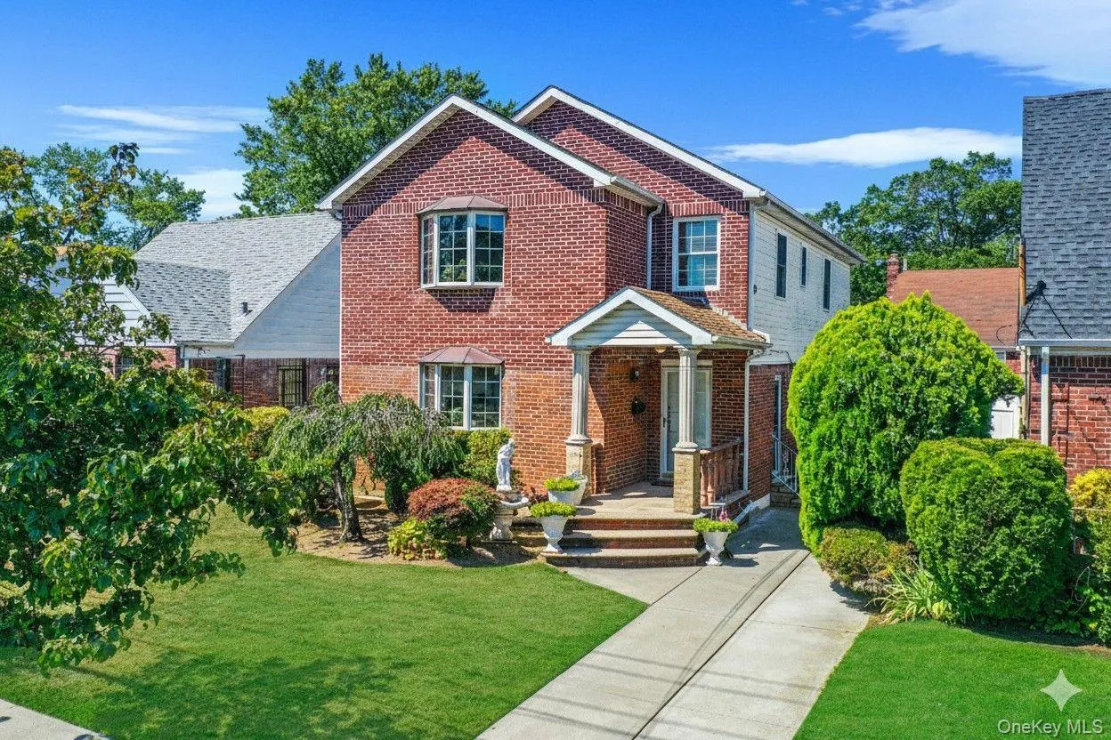 Traditional-style house featuring a front yard and brick siding Traditional-style house featuring a front yard and brick siding