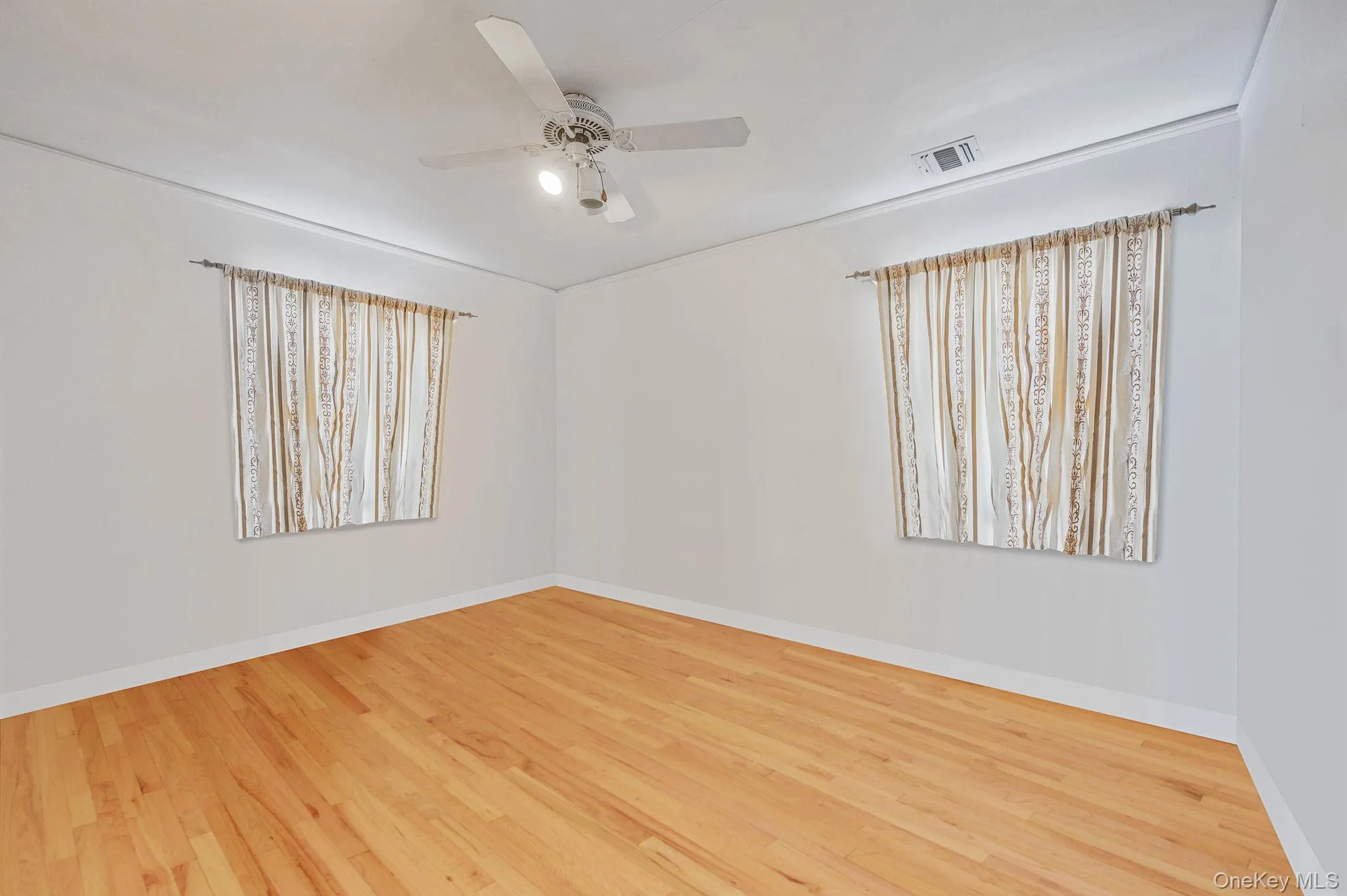 Spare room with wood finished floors and ceiling fan Spare room with wood finished floors and ceiling fan