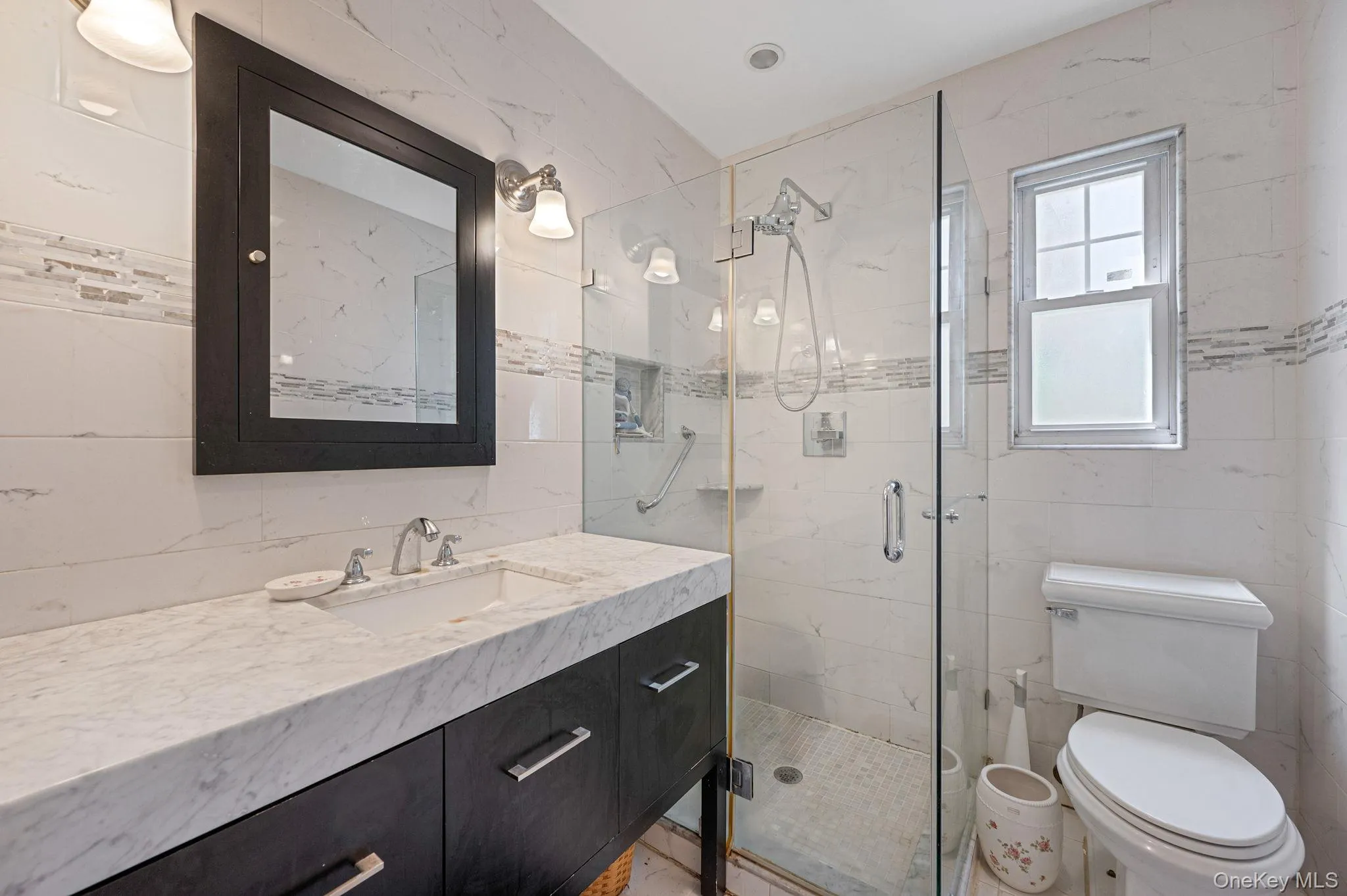 Full bath featuring tile walls, vanity, and a stall shower Full bath featuring tile walls, vanity, and a stall shower