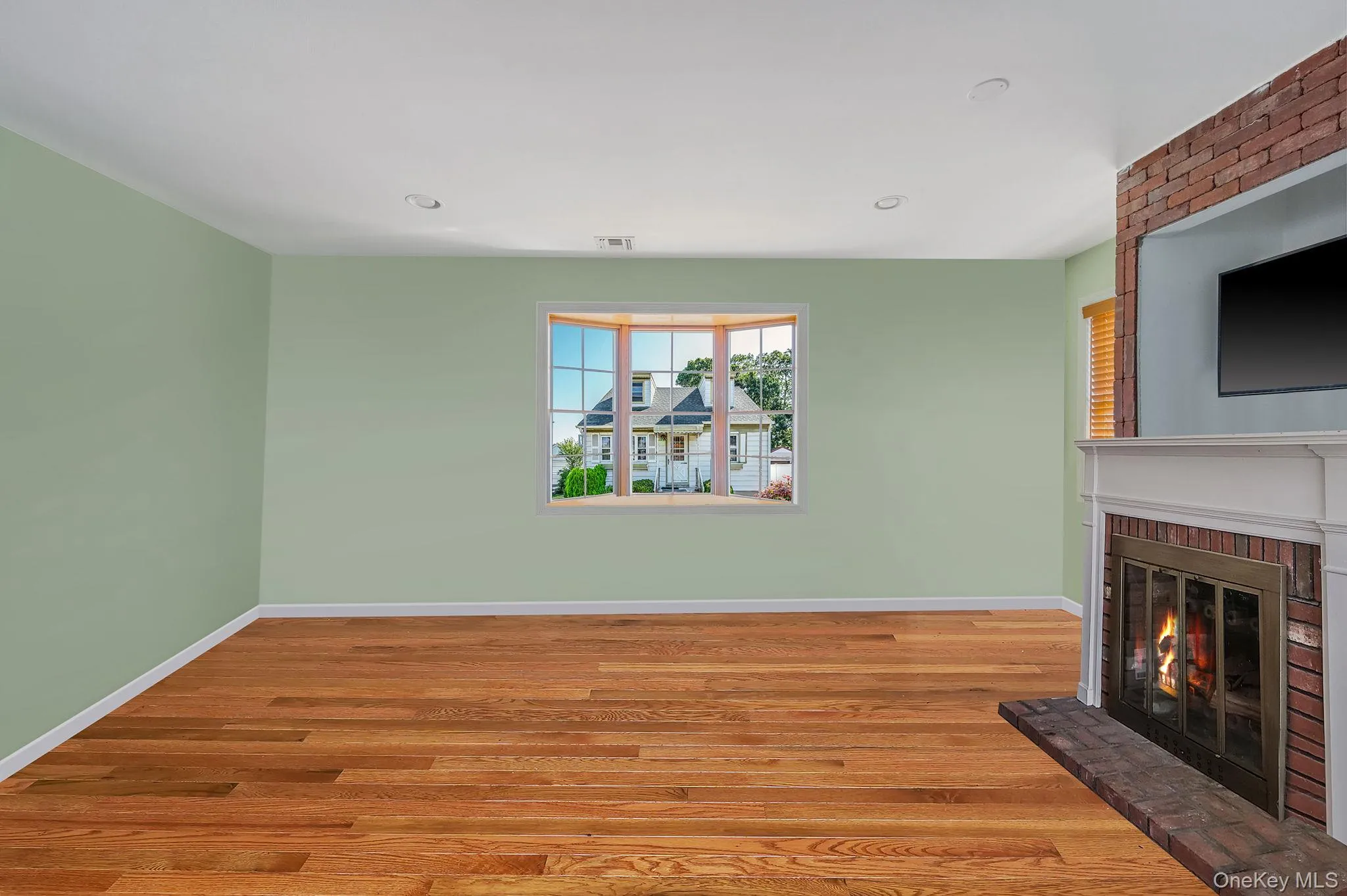 Unfurnished living room featuring wood finished floors, a fireplace, and recessed lighting Unfurnished living room featuring wood finished floors, a fireplace, and recessed lighting