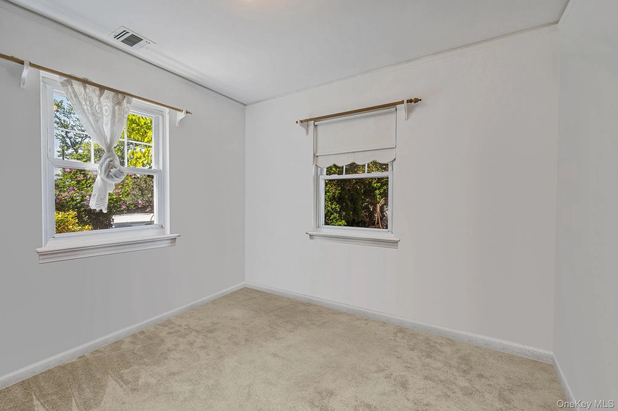 Carpeted empty room featuring plenty of natural light Carpeted empty room featuring plenty of natural light
