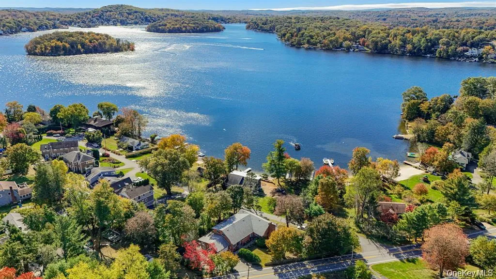 Aerial view of residential area with a large body of water and a forest Aerial view of residential area with a large body of water and a forest