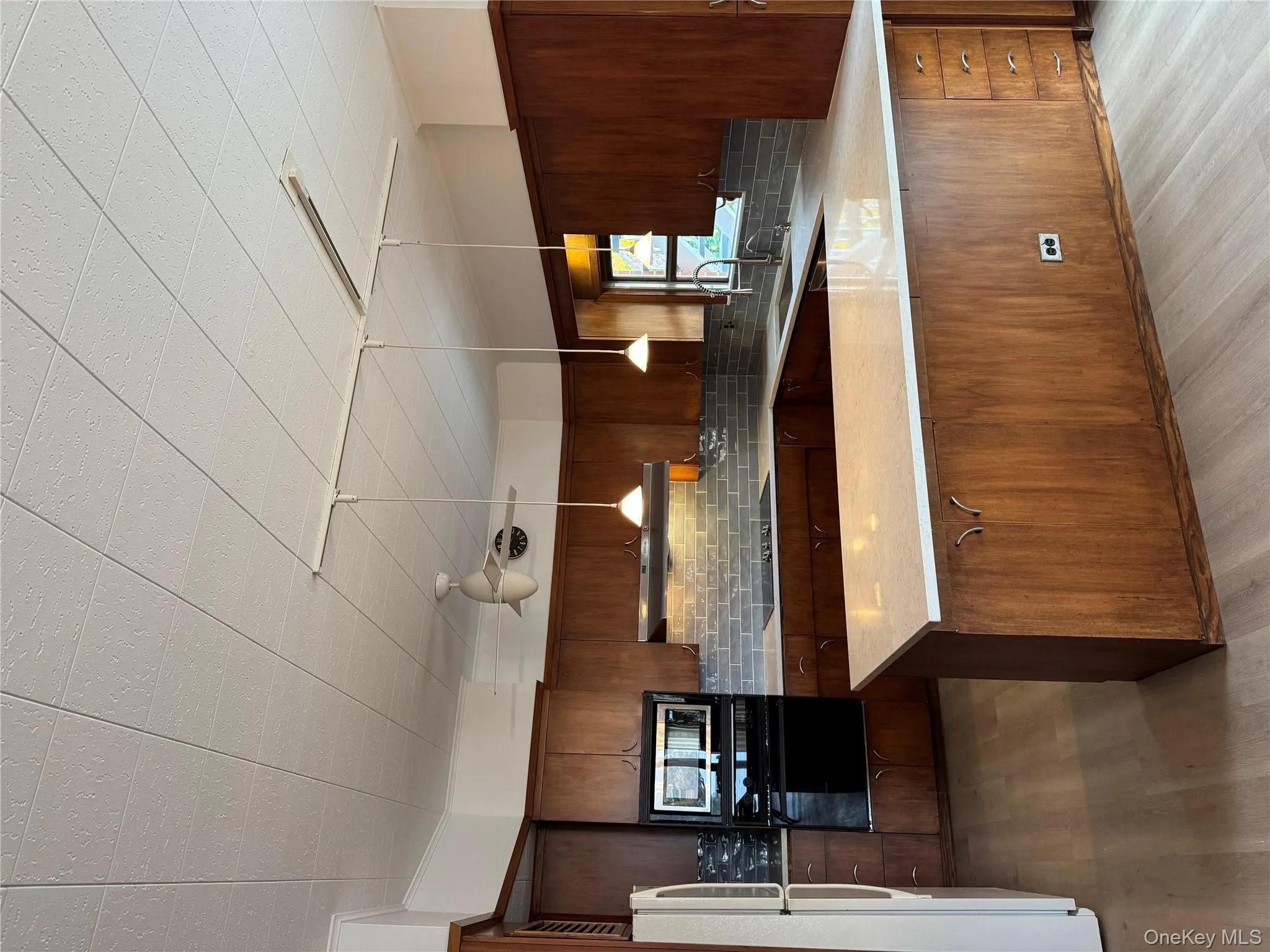 Kitchen featuring hanging light fixtures, wall oven, a peninsula, and light wood-style floors Kitchen featuring hanging light fixtures, wall oven, a peninsula, and light wood-style floors