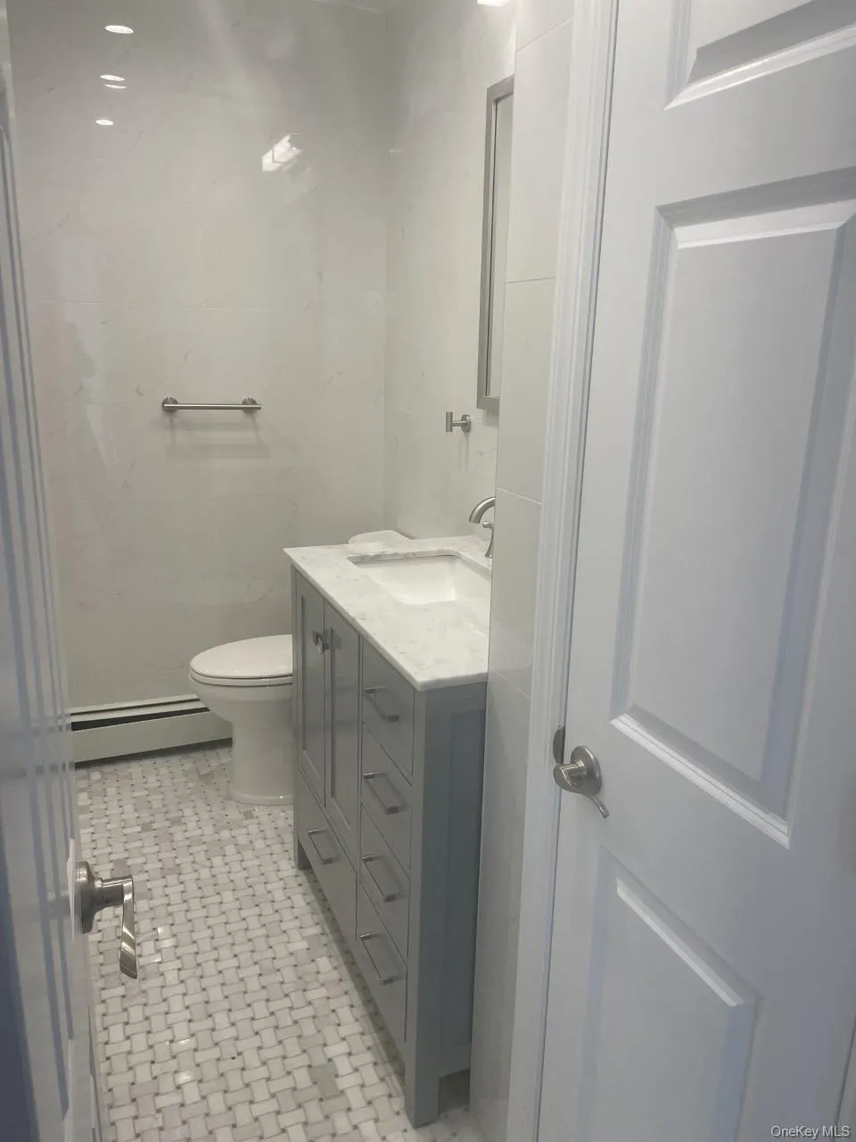 Bathroom featuring vanity and baseboard heating Bathroom featuring vanity and baseboard heating