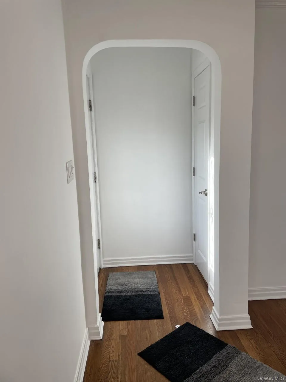 Hallway featuring dark wood-style floors and arched walkways Hallway featuring dark wood-style floors and arched walkways