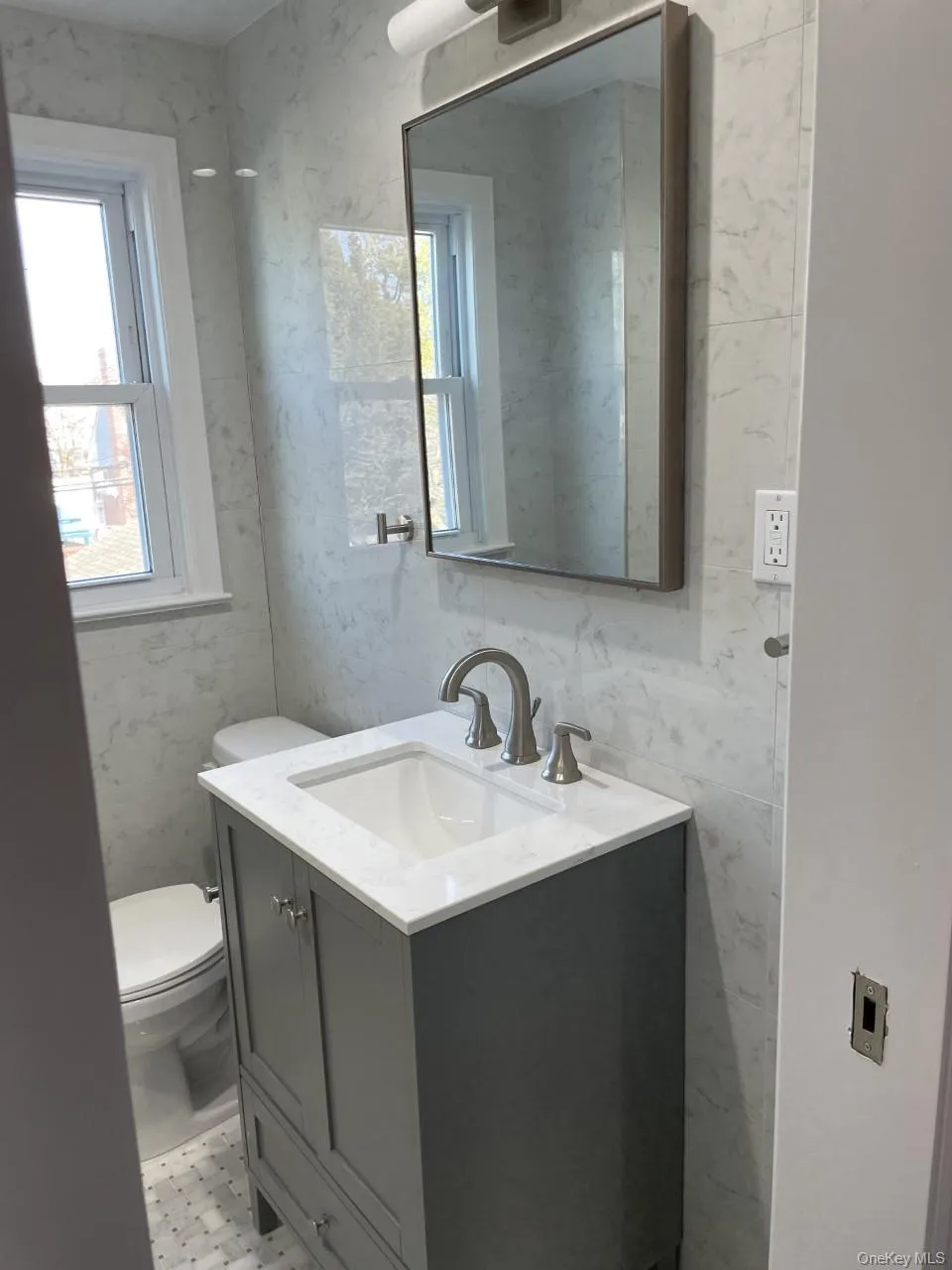 Half bathroom featuring vanity and tile walls Half bathroom featuring vanity and tile walls