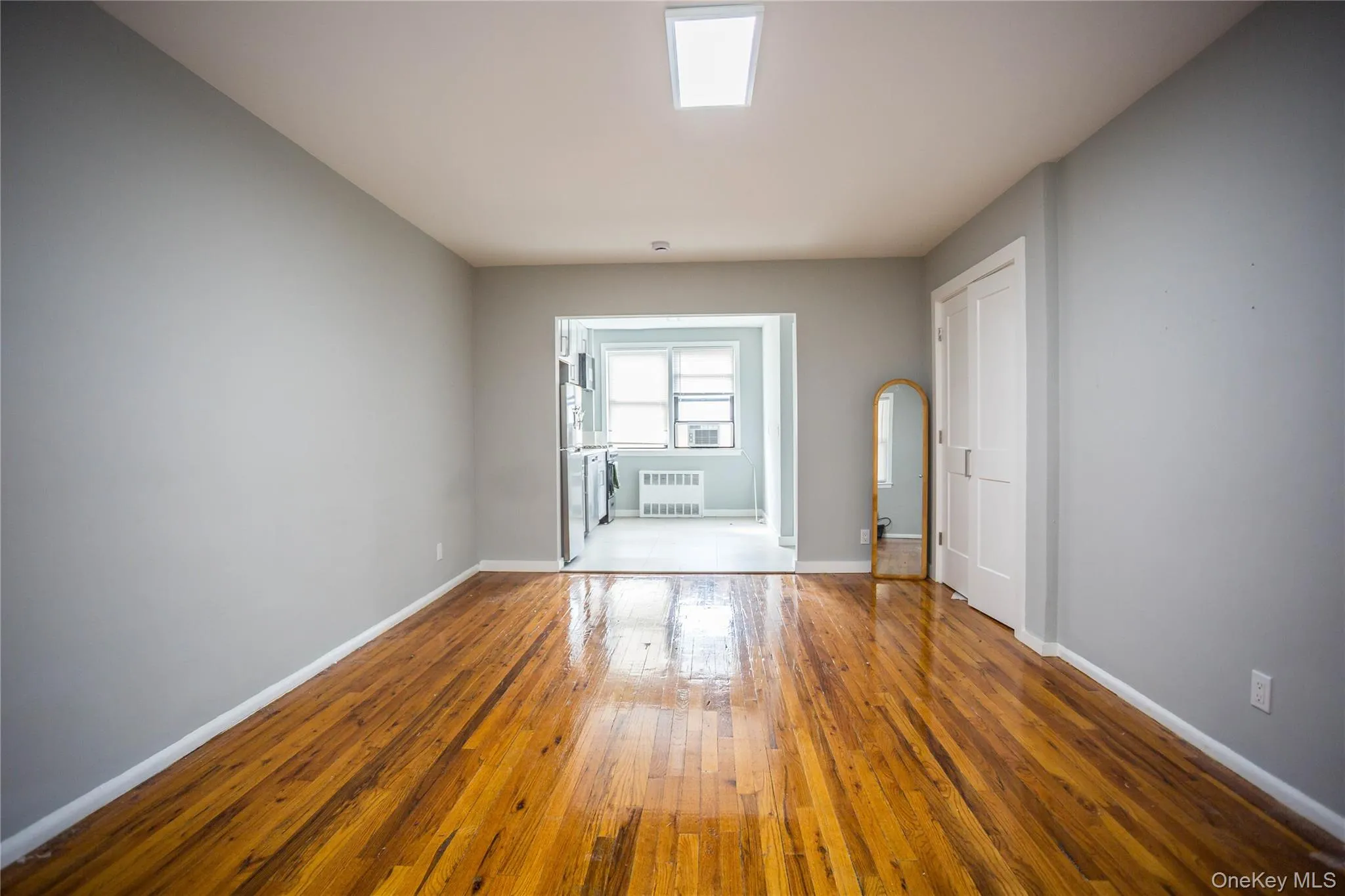 Empty room with hardwood / wood-style floors and radiator heating unit Empty room with hardwood / wood-style floors and radiator heating unit
