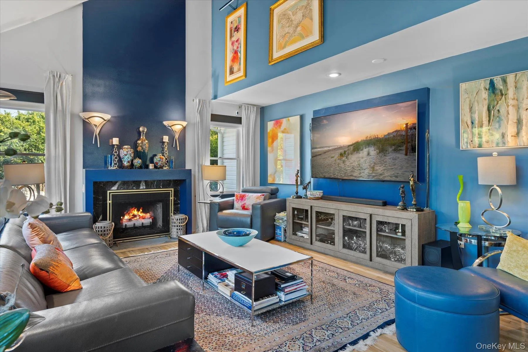 Living area with wood finished floors, a premium fireplace, and a high ceiling Living area with wood finished floors, a premium fireplace, and a high ceiling