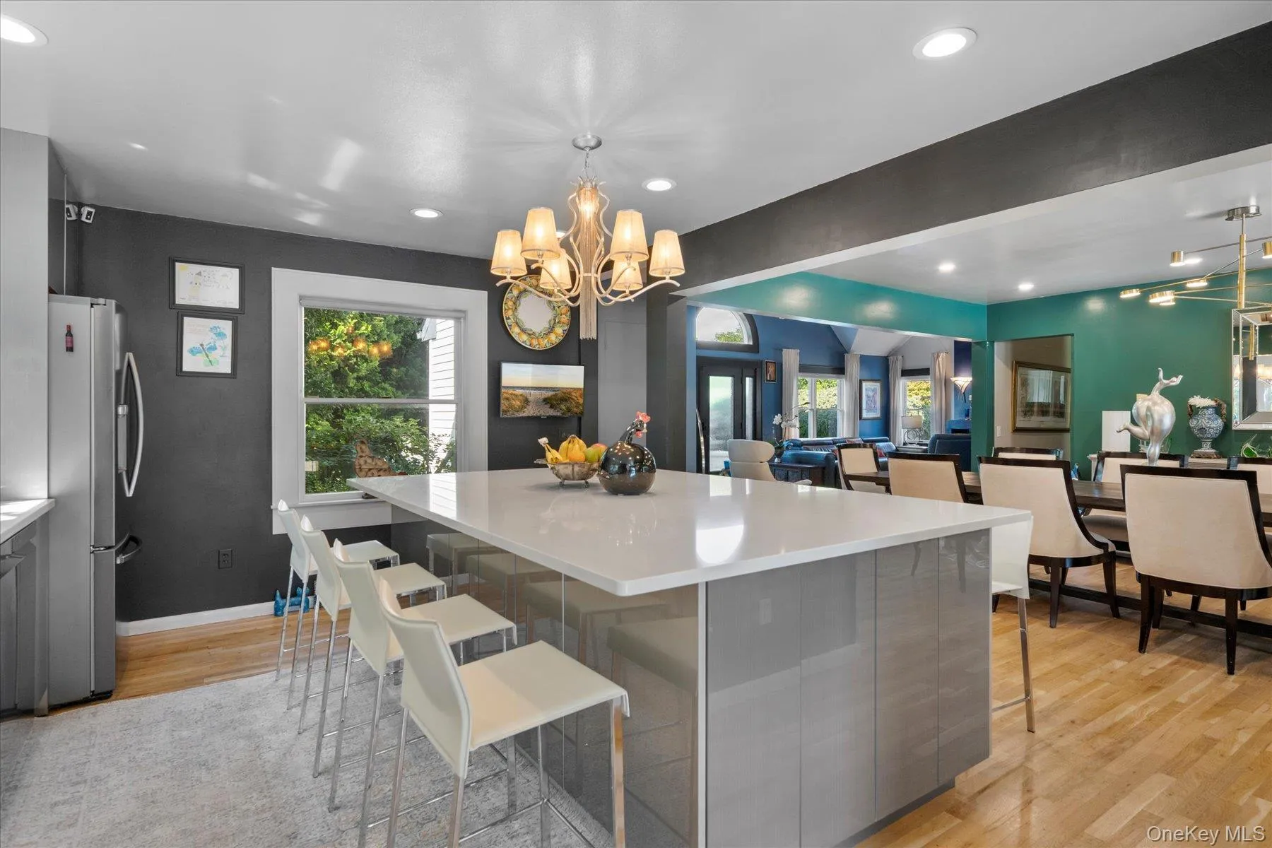 Kitchen with a kitchen breakfast bar, healthy amount of natural light, gray cabinets, freestanding refrigerator, and recessed lighting Kitchen with a kitchen breakfast bar, healthy amount of natural light, gray cabinets, freestanding refrigerator, and recessed lighting