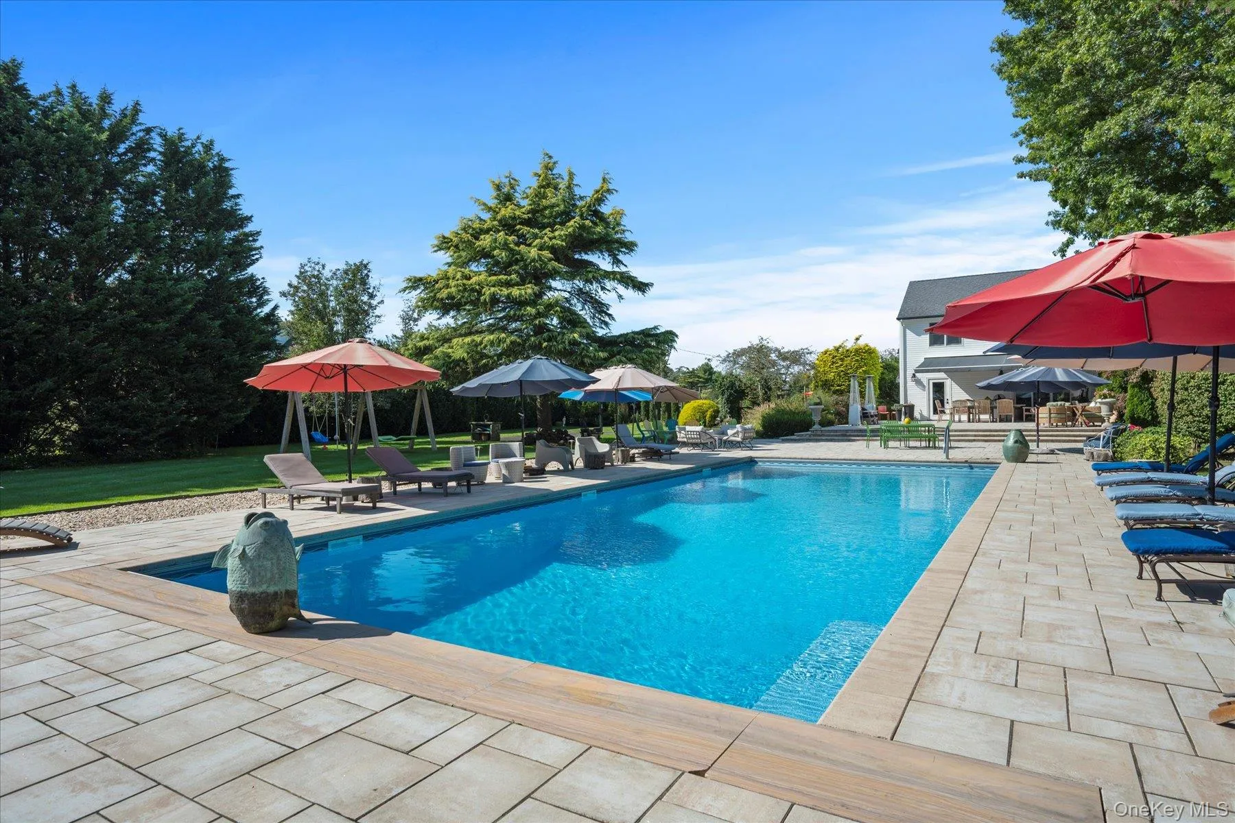 Outdoor pool with a patio area and a lawn Outdoor pool with a patio area and a lawn
