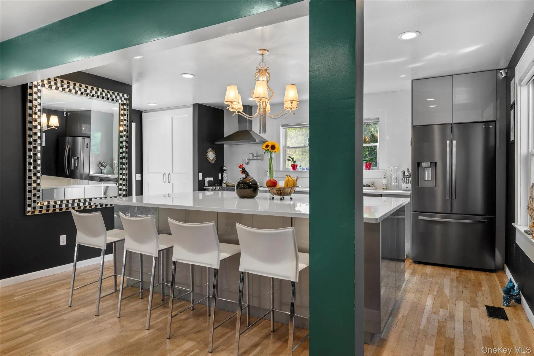Kitchen featuring stainless steel fridge, gray cabinetry, hanging light fixtures, light wood-style floors, and recessed lighting Kitchen featuring stainless steel fridge, gray cabinetry, hanging light fixtures, light wood-style floors, and recessed lighting