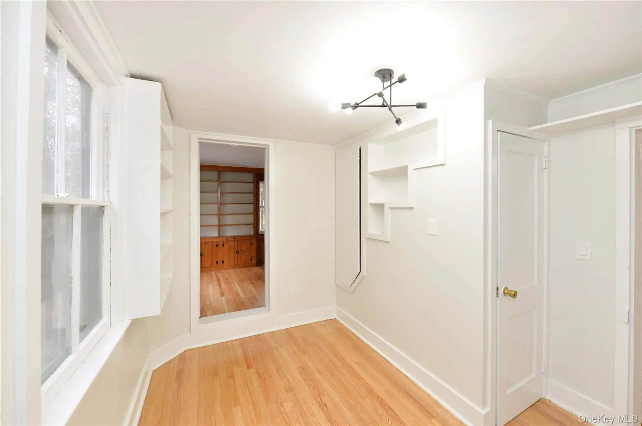 Unfurnished bedroom with a chandelier and light wood-style flooring Unfurnished bedroom with a chandelier and light wood-style flooring