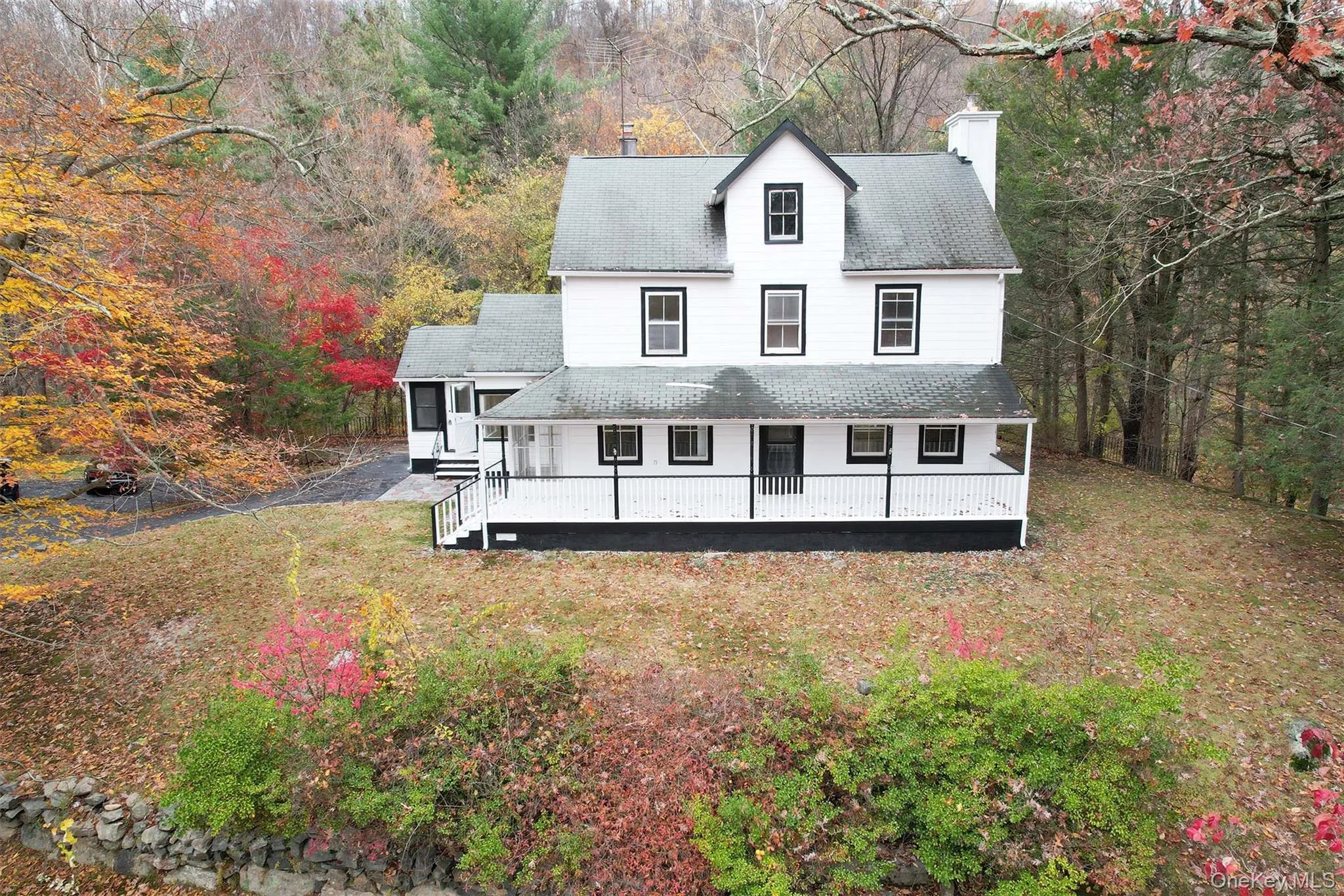 View of front of property with roof with shingles, a chimney, a porch, and a front lawn View of front of property with roof with shingles, a chimney, a porch, and a front lawn