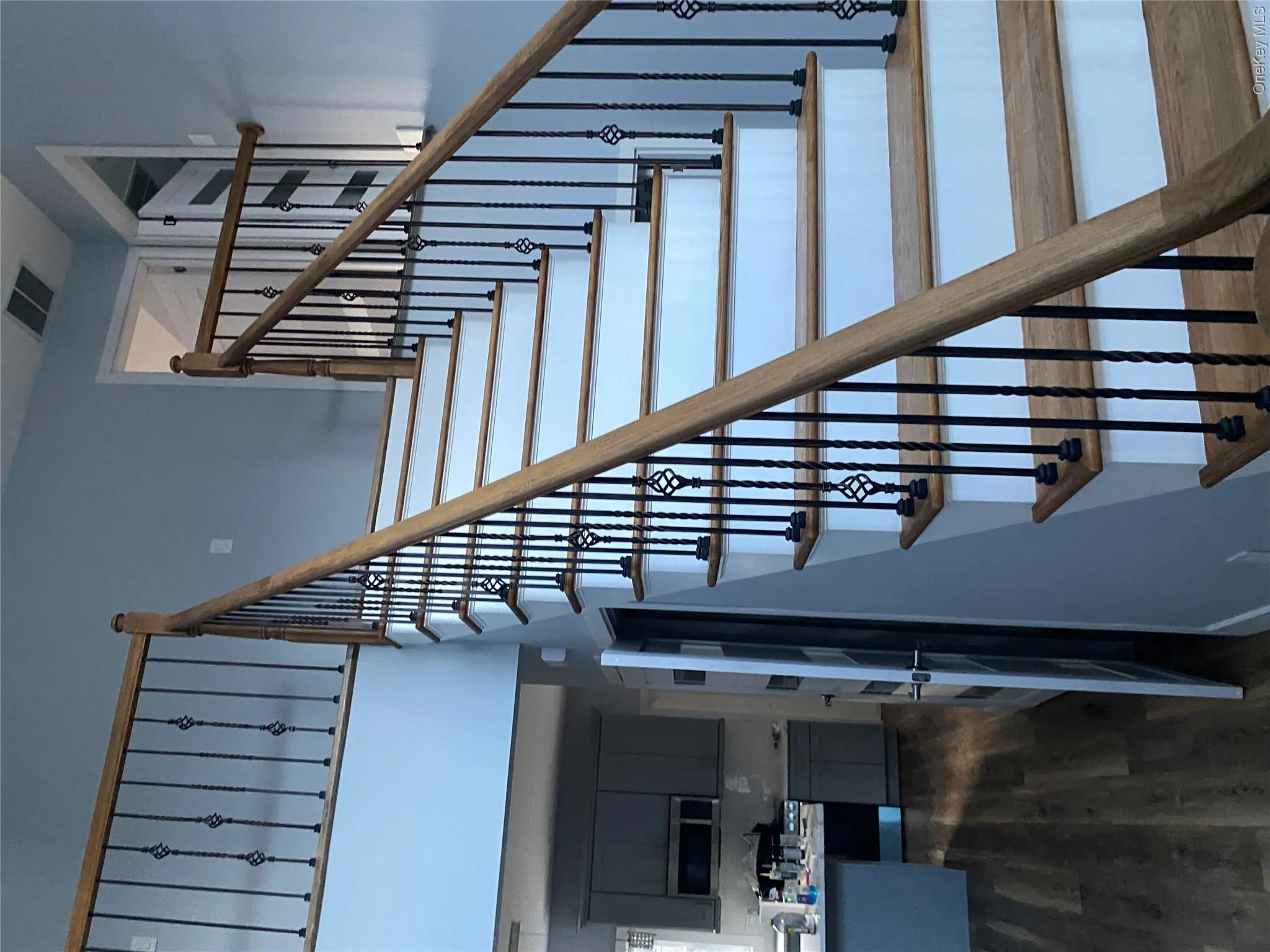Stairway featuring wood finished floors and a high ceiling Stairway featuring wood finished floors and a high ceiling