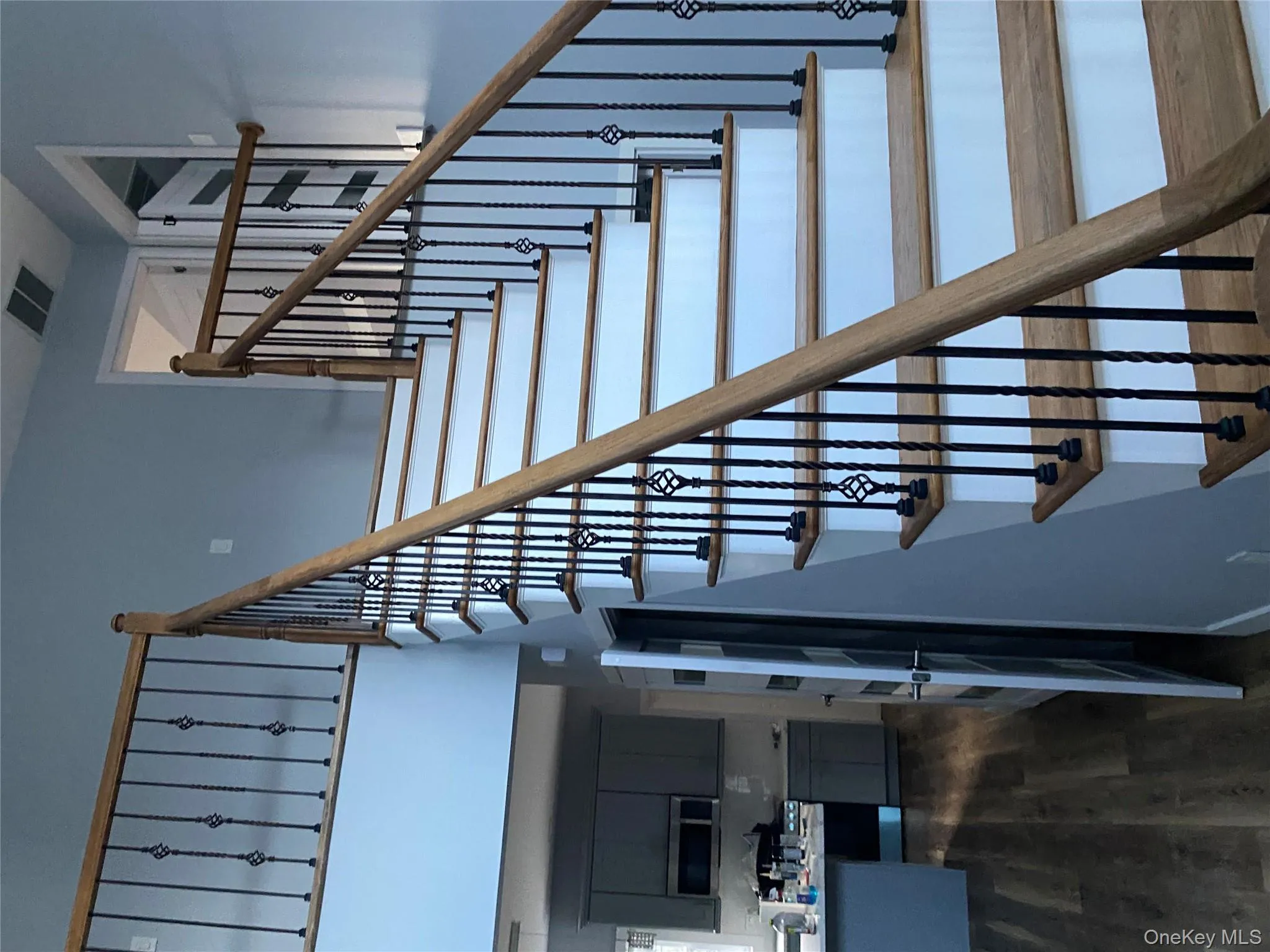 Stairway featuring wood finished floors and a high ceiling Stairway featuring wood finished floors and a high ceiling