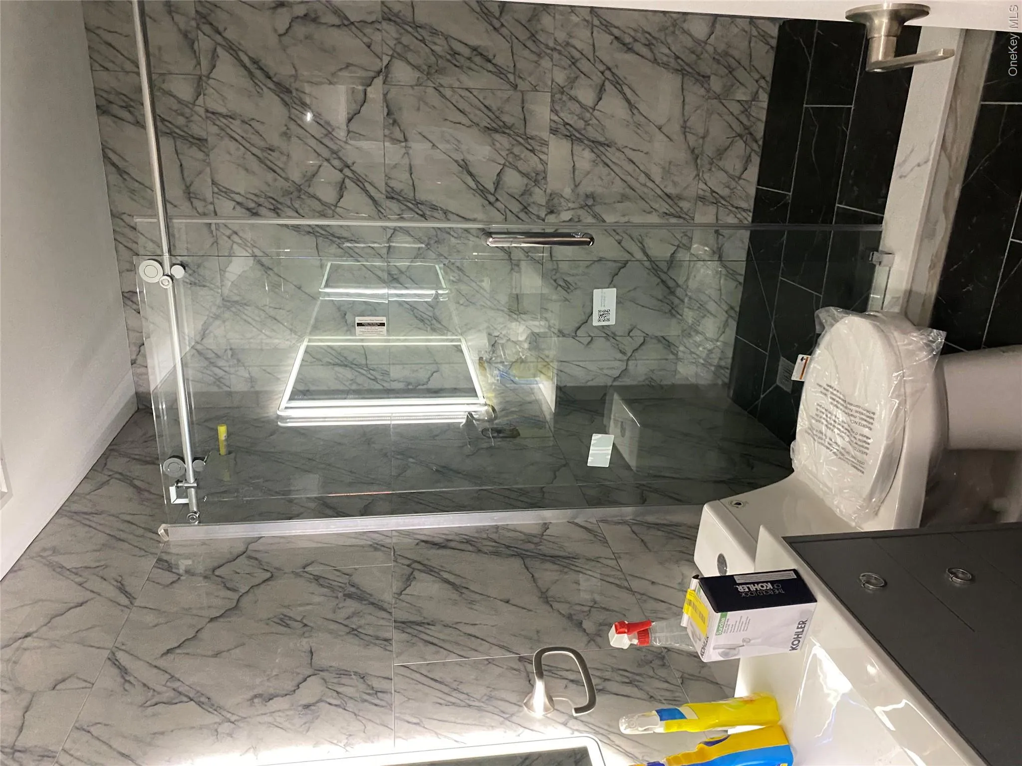Bathroom with tile walls, vanity, and a marble finish shower Bathroom with tile walls, vanity, and a marble finish shower