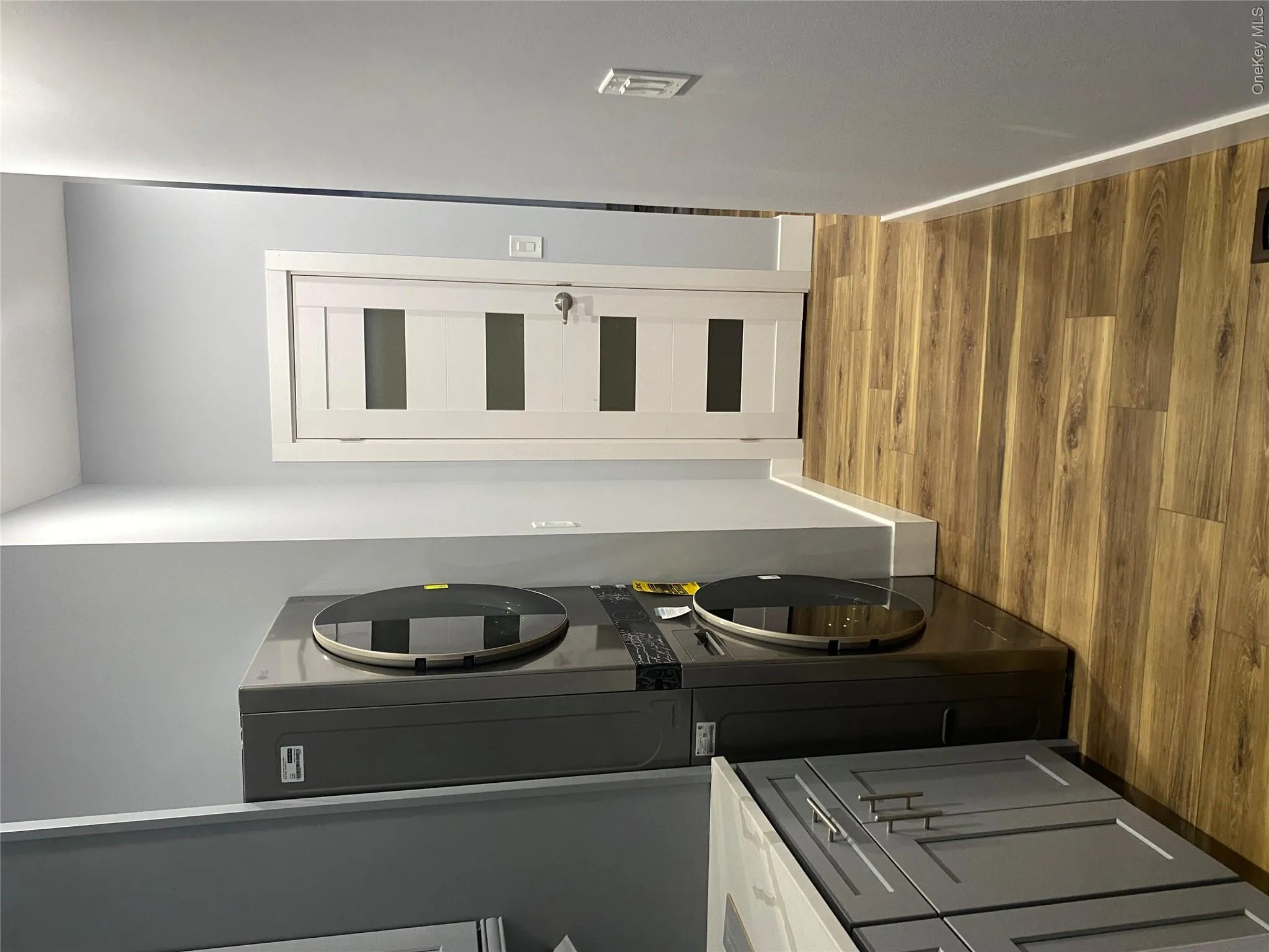 Laundry area featuring light wood finished floors and stacked washer / drying machine Laundry area featuring light wood finished floors and stacked washer / drying machine