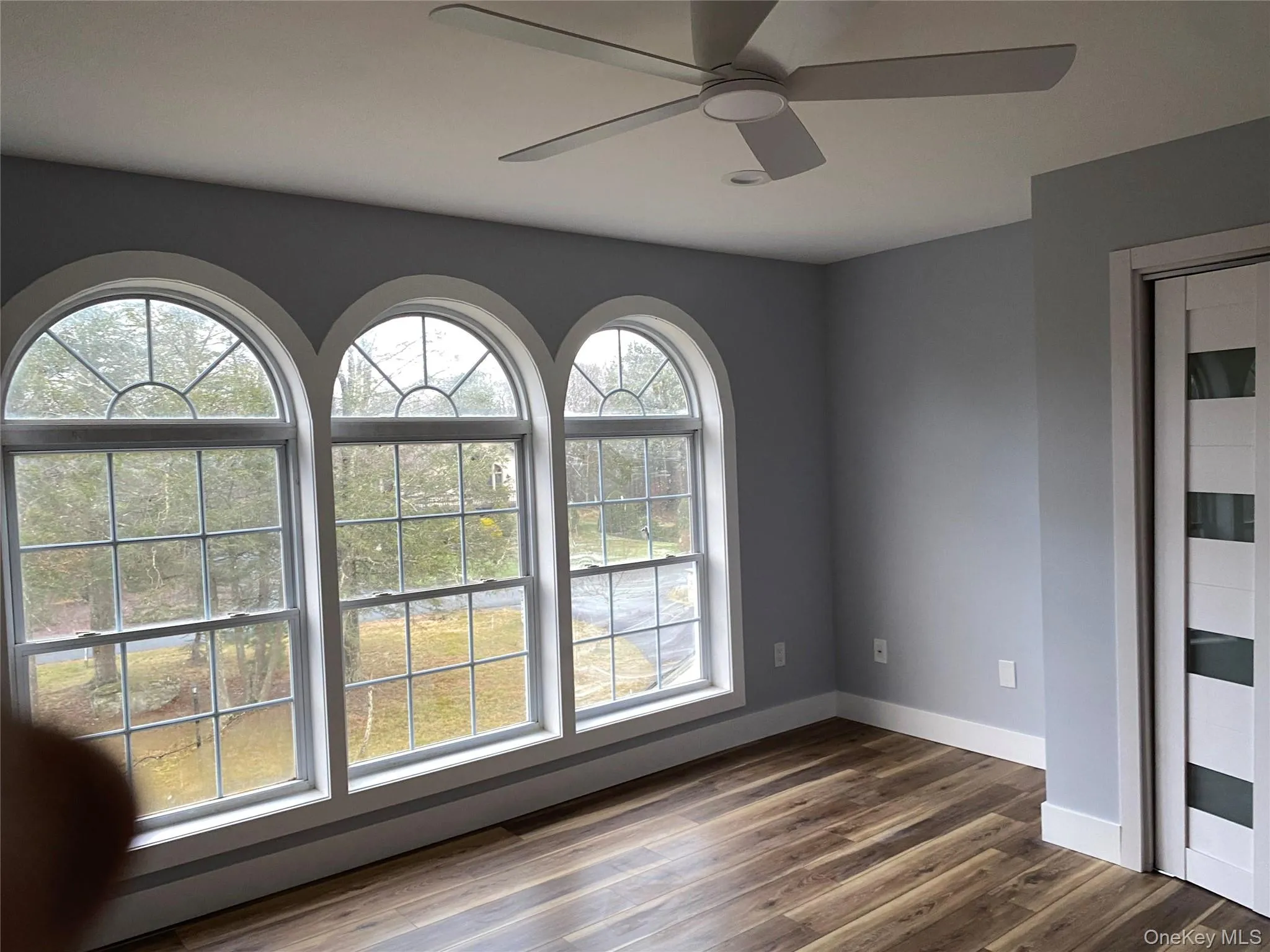 Spare room featuring dark wood-type flooring and a ceiling fan Spare room featuring dark wood-type flooring and a ceiling fan