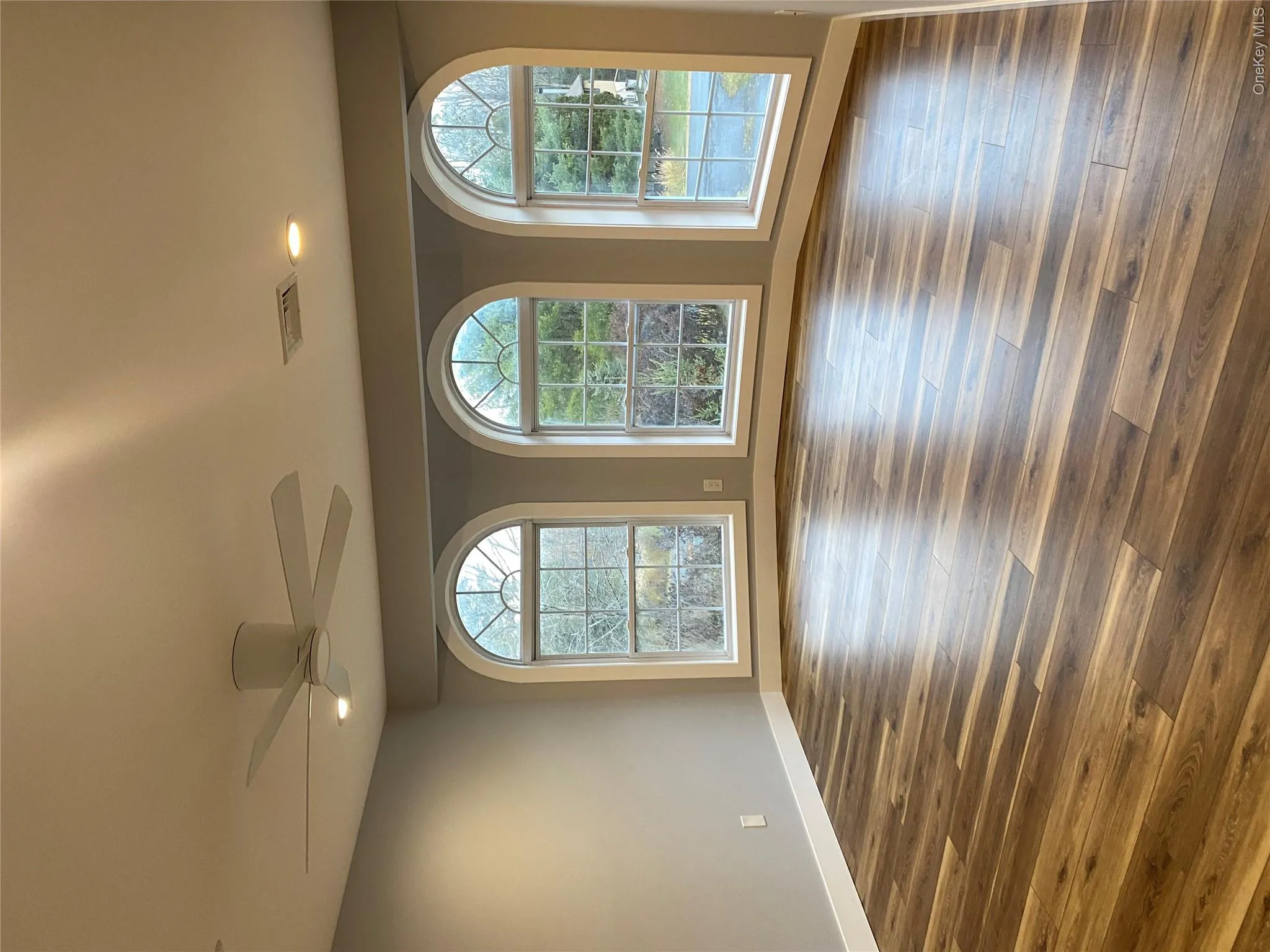 Empty room featuring recessed lighting, healthy amount of natural light, dark wood finished floors, and a ceiling fan Empty room featuring recessed lighting, healthy amount of natural light, dark wood finished floors, and a ceiling fan
