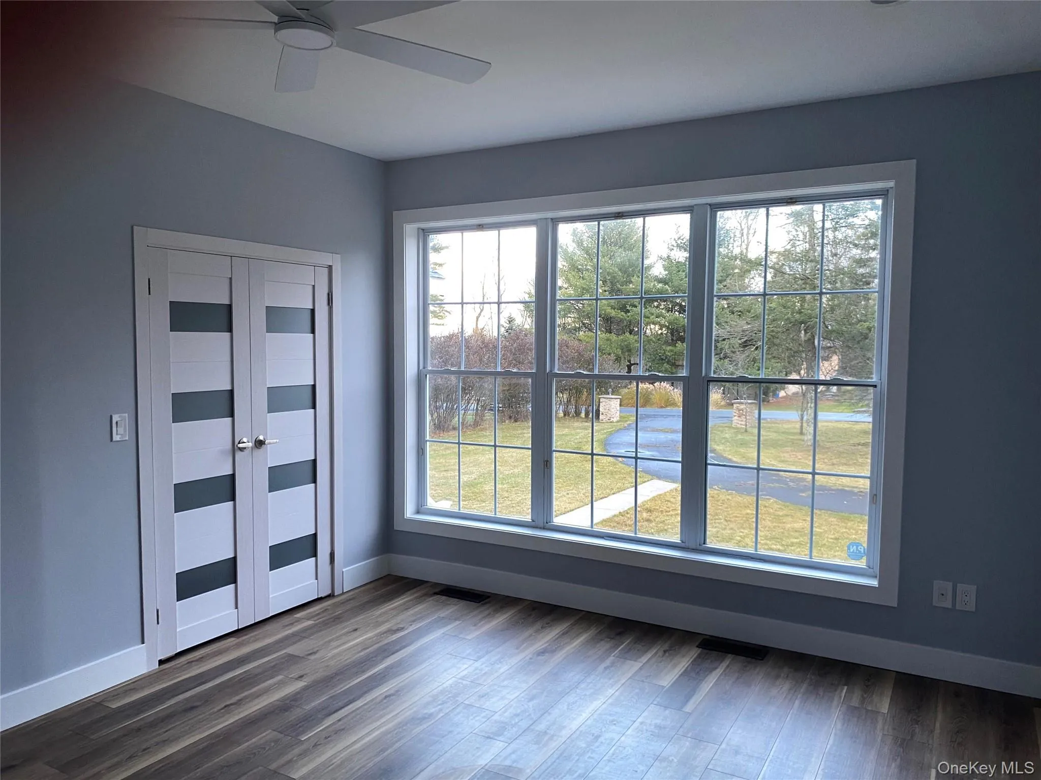 Unfurnished room with baseboards and dark wood-type flooring Unfurnished room with baseboards and dark wood-type flooring