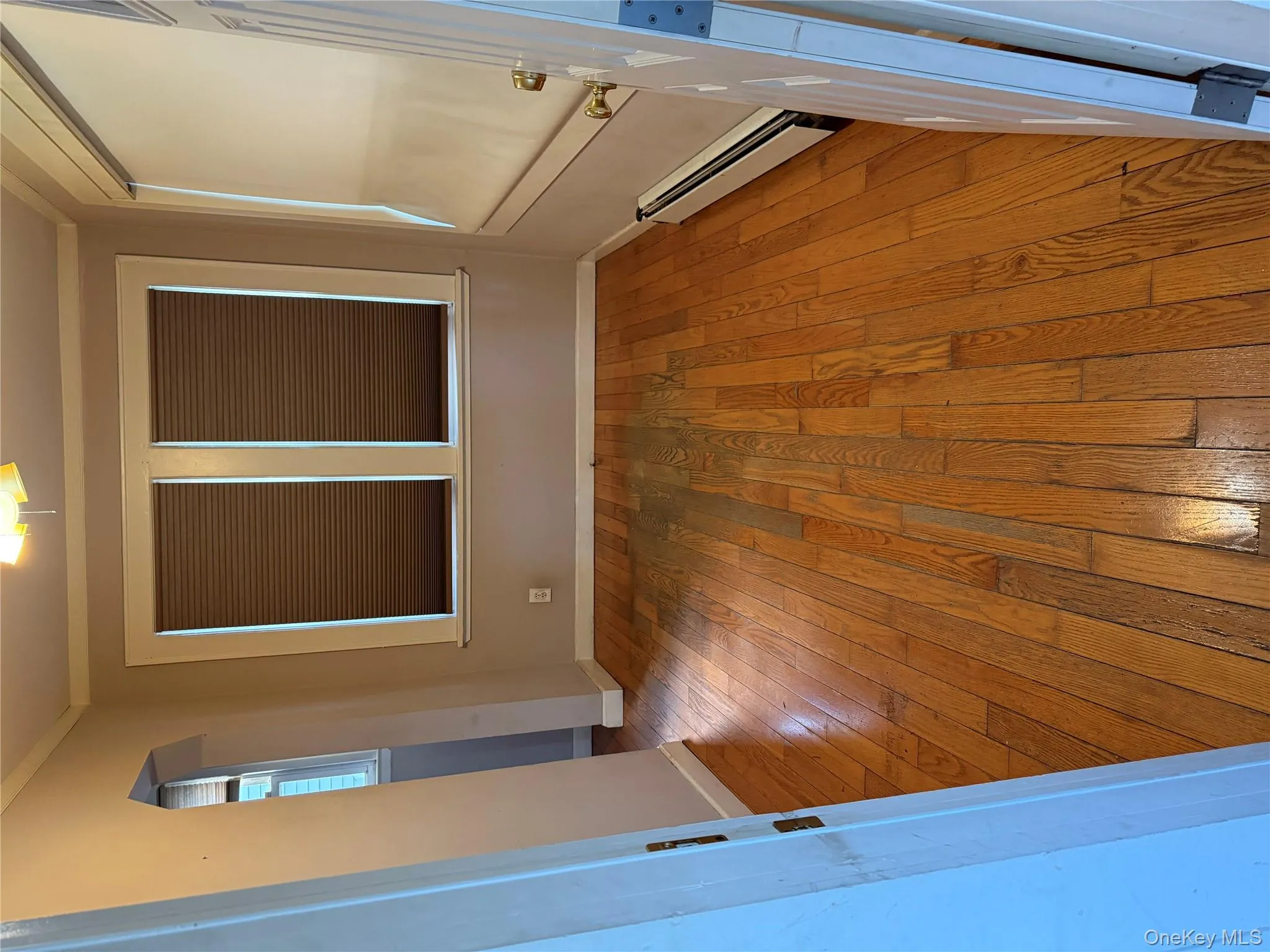 Empty room featuring arched walkways, light wood finished floors, a baseboard radiator, and crown molding Empty room featuring arched walkways, light wood finished floors, a baseboard radiator, and crown molding
